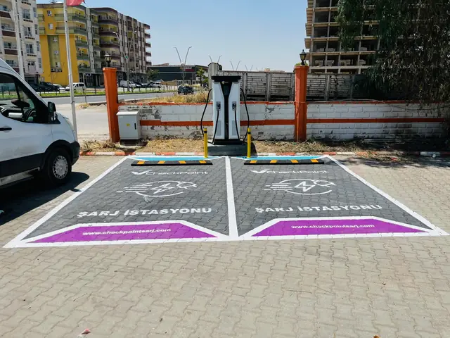 Duvar önünde DC şarj ünitesi ve önünde iki işaretli şarj yeri